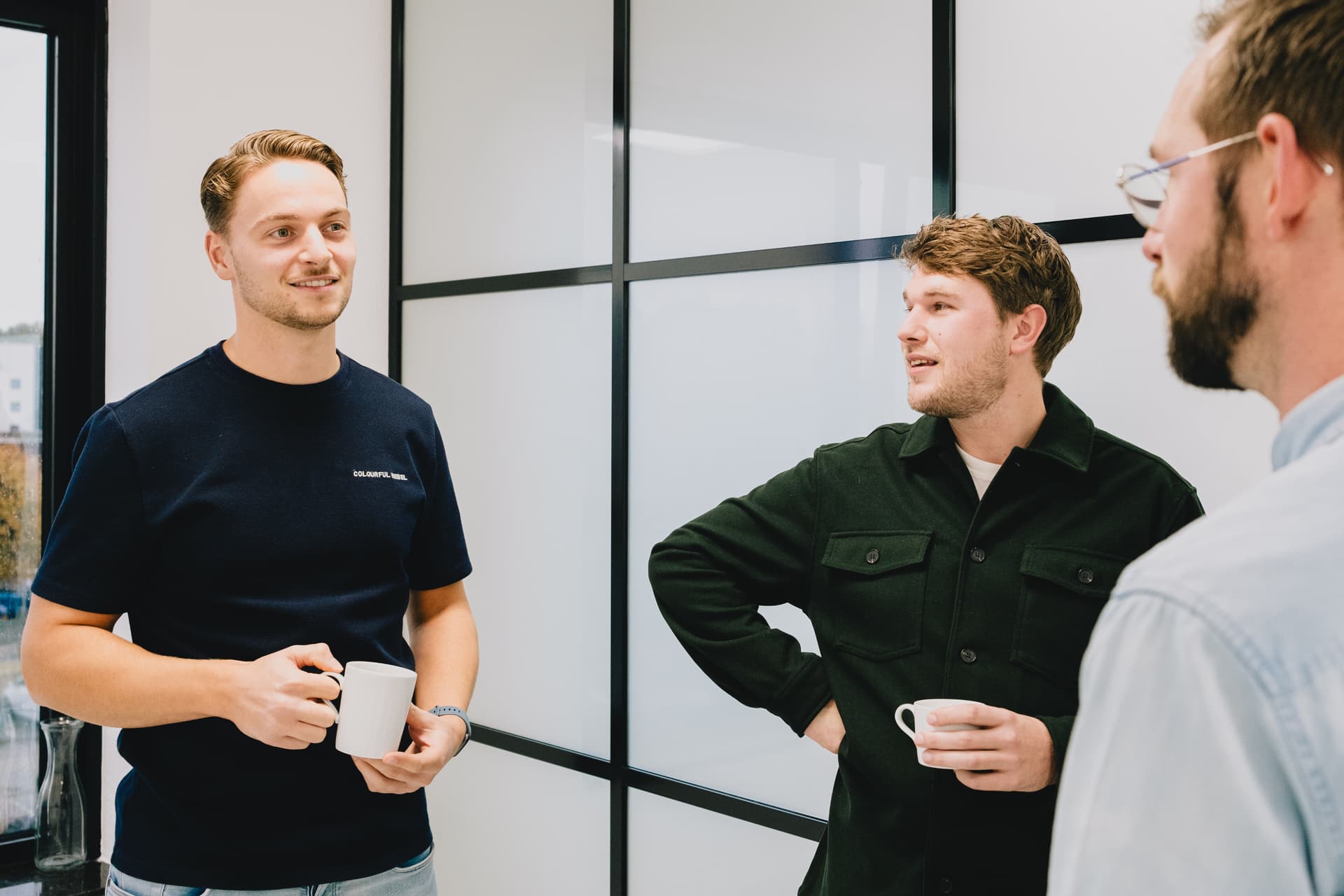 Sam, Leendert en Joost praten met elkaar tijdens een koffiepauze